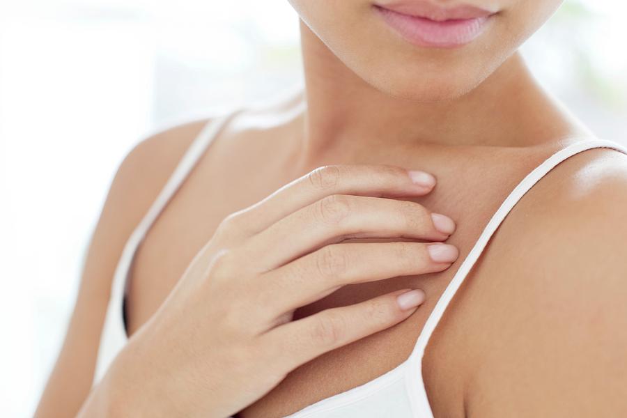 Woman touching her chest - Stock Image - F020/9747 - Science Photo Library