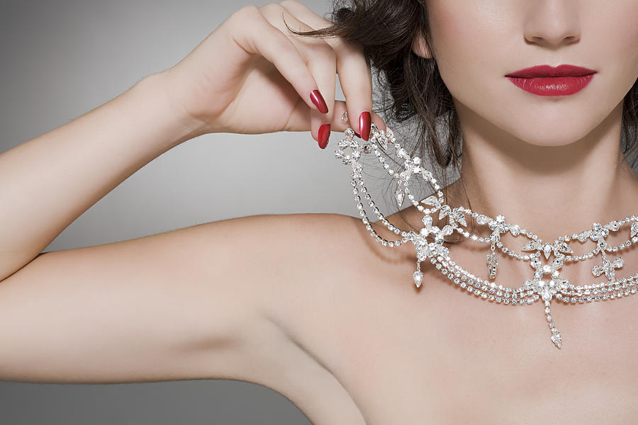 Woman trying on a diamond necklace Photograph by Image Source