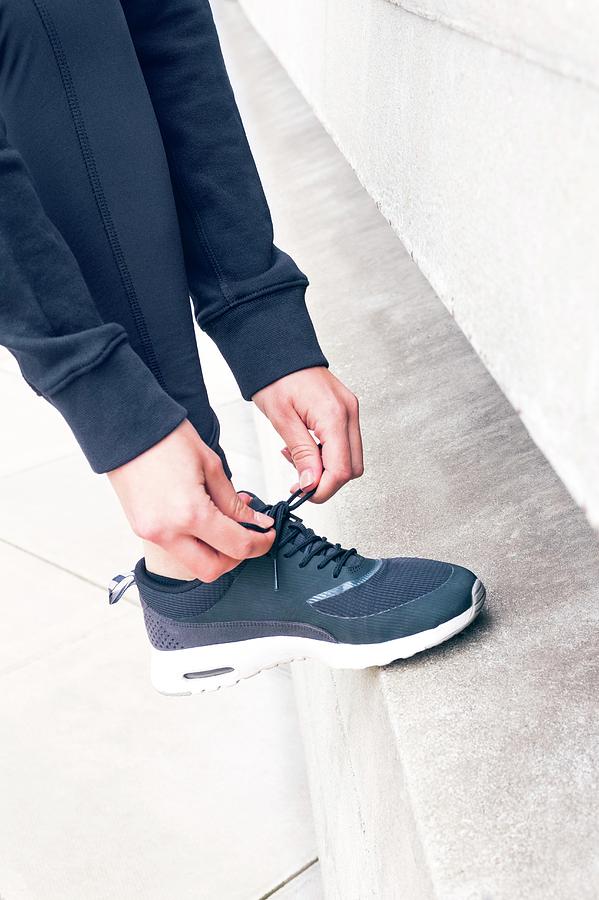 Woman Tying Trainers With Foot On Step Photograph by Ian Hooton/science ...