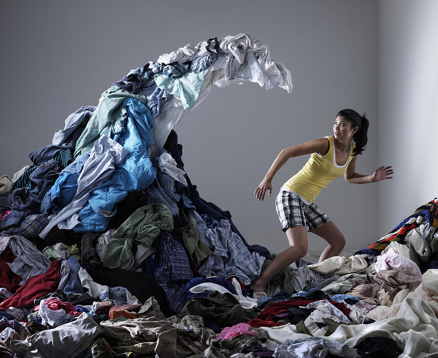 Woman underneath wave of laundry Photograph by Ryan McVay