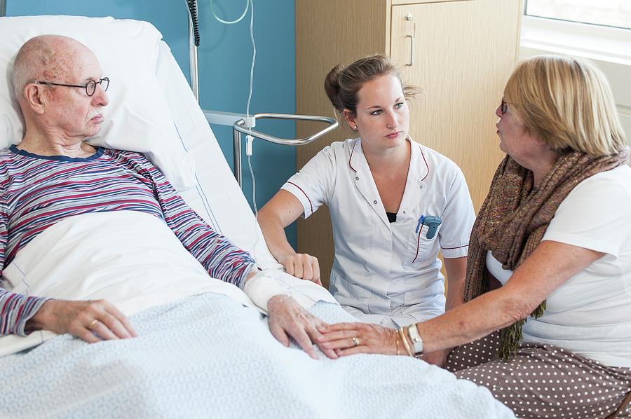 Woman Visiting Senior Man Talking To Nurse Photograph By Arno Massee