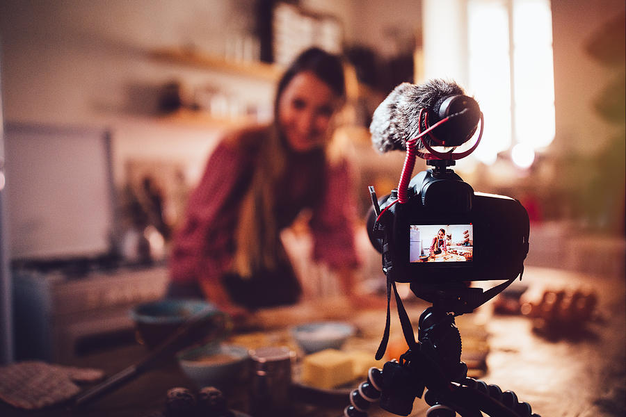 Woman vlogger baking and recording video for food channel Photograph by Wundervisuals