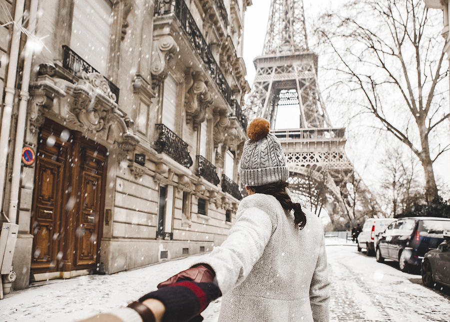 Woman walking to the Eiffel tower with snow Photograph by Orbon Alija