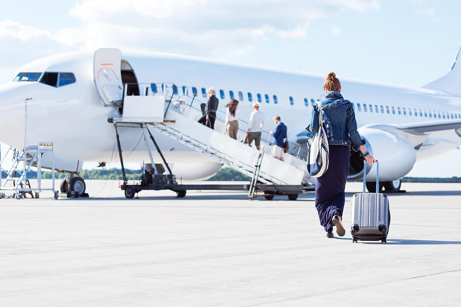 Woman walking towards the airplane Photograph by Izusek