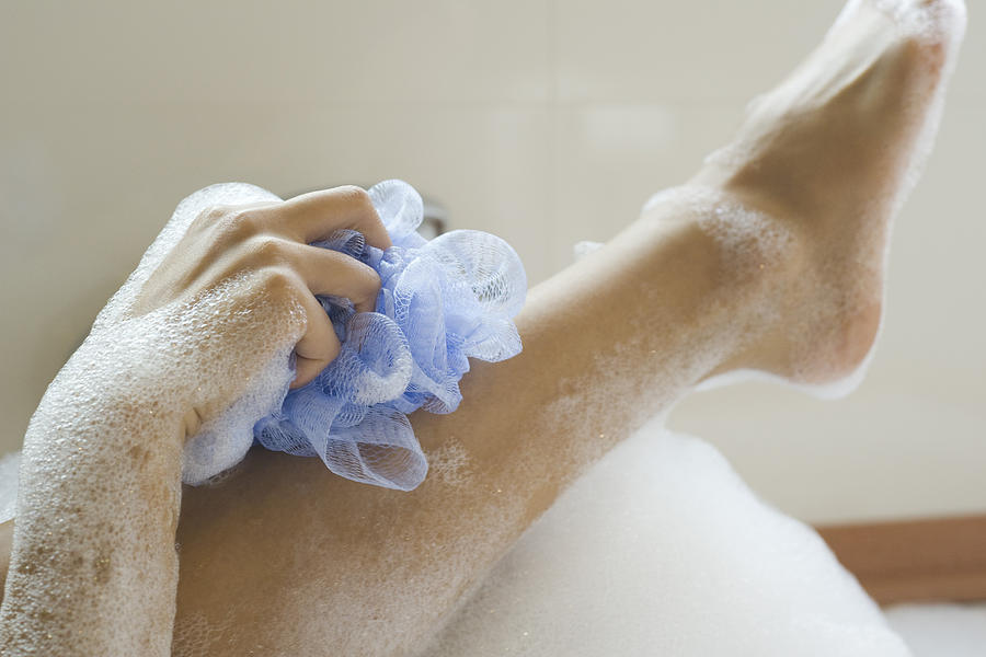 Woman washing leg in bath, cropped Photograph by ZenShui/Frederic Cirou