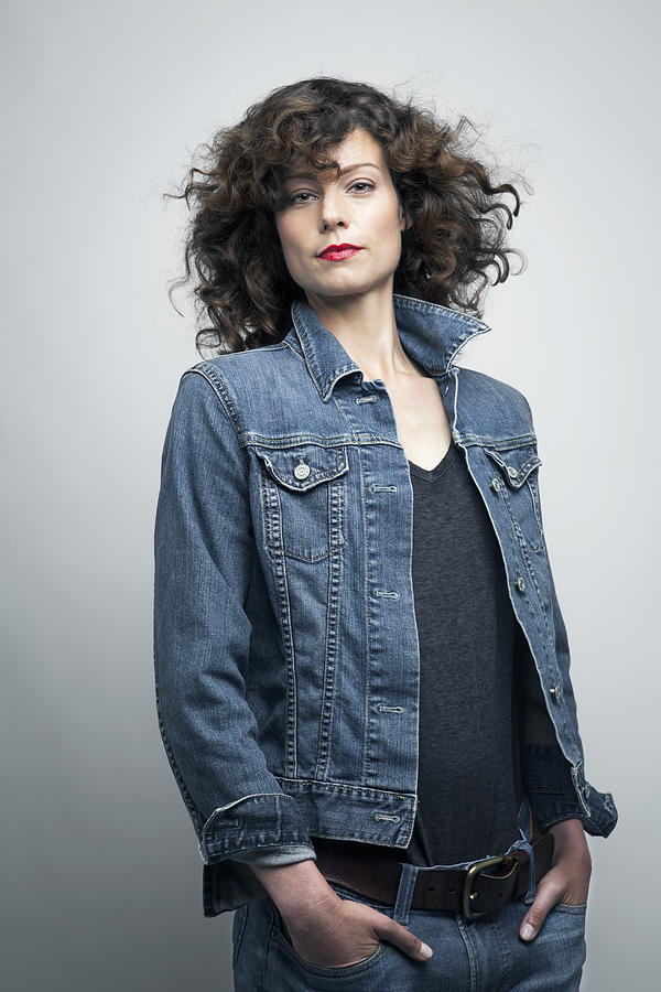 Woman wearing a jeans jacket, portrait. Photograph by Andreas Kuehn