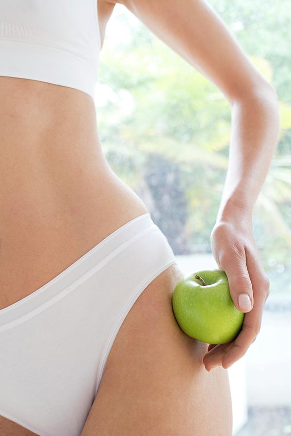 Woman Wearing White Underwear Holding Apple by Ian Hooton/science Photo  Library