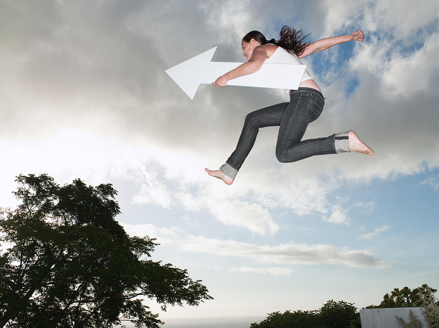 Woman with blank arrow leaping outdoors Photograph by Robert Daly
