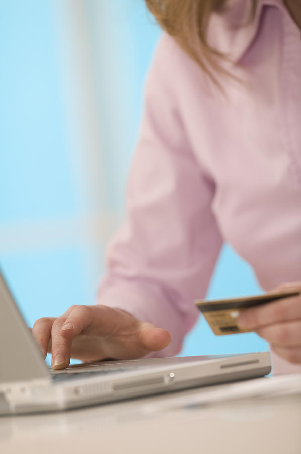 Woman with laptop and credit card Photograph by Comstock Images