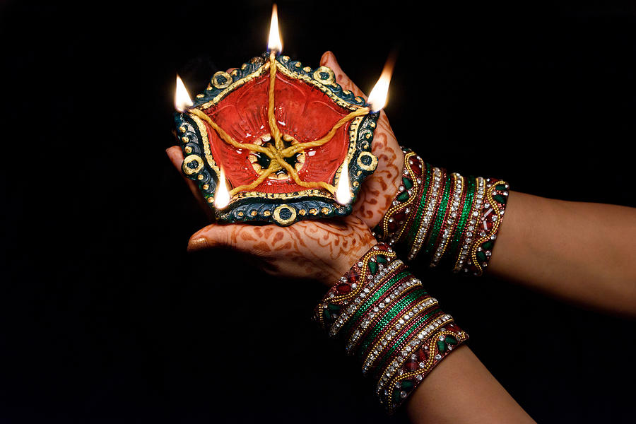 Woman with lit earthen lamp at Diwali festival,India. Photograph by Subir Basak