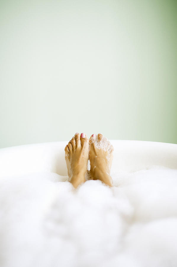 Womans Feet Emerging in Bubble Bath Photograph by Stevecoleimages