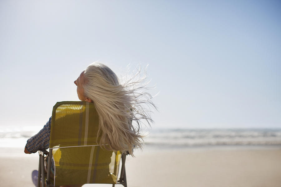 Womans hair blowing in wind on beach Photograph by Tom Merton