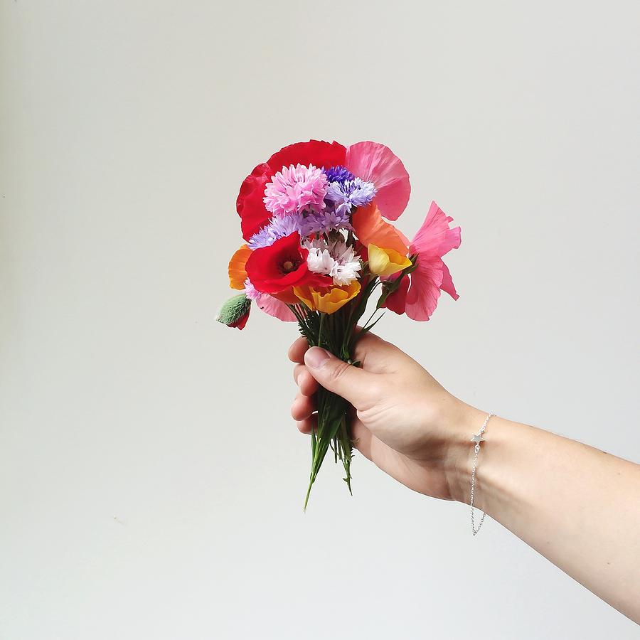 Womans Hand Holding Bunch Of Wildflowers Photograph by Hannahargyle