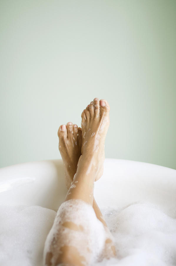 Womans Legs and Feet in Bathtub with Bubbles Photograph by Stevecoleimages