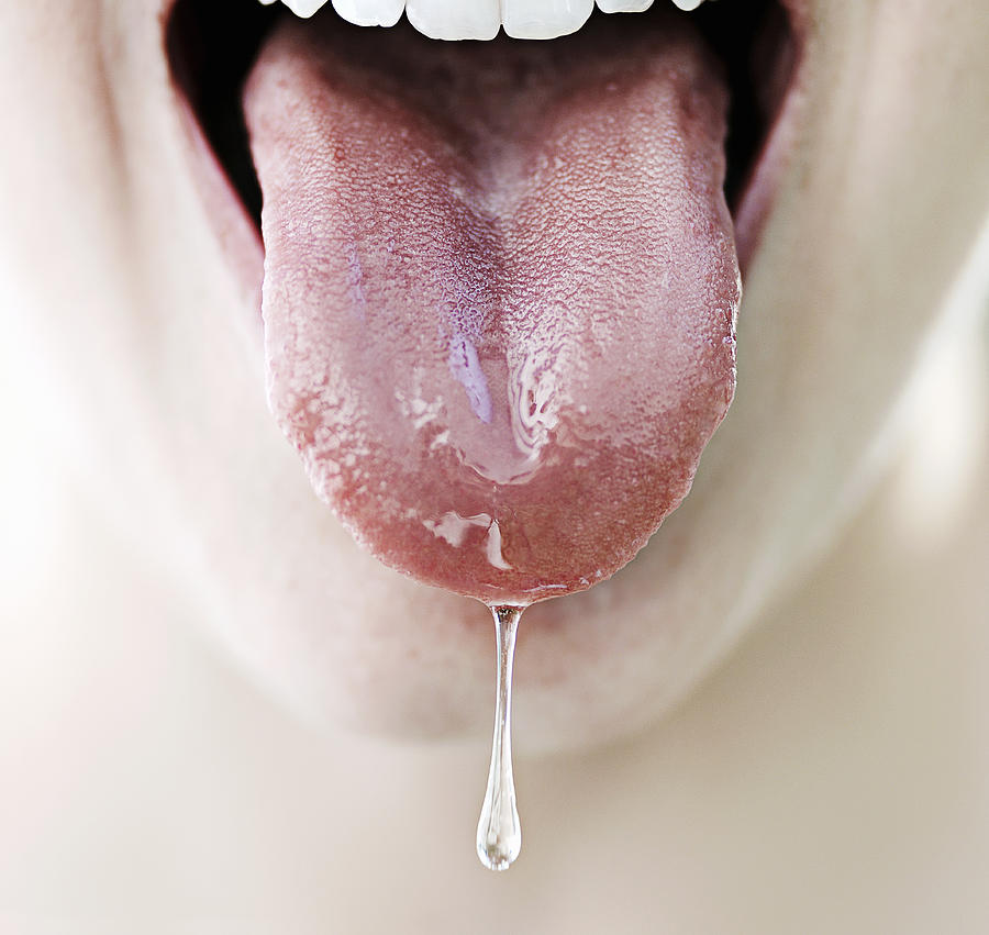 Womans tongue dripping with saliva, close-up Photograph by David Trood