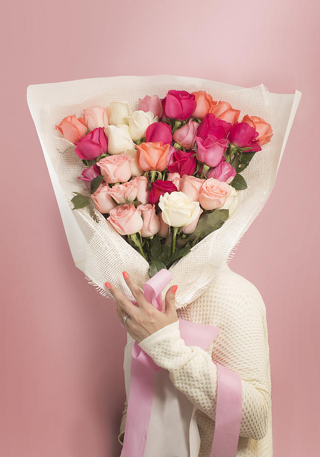 Womens holding a big bouquet of roses on pink background. Photograph by Twomeows
