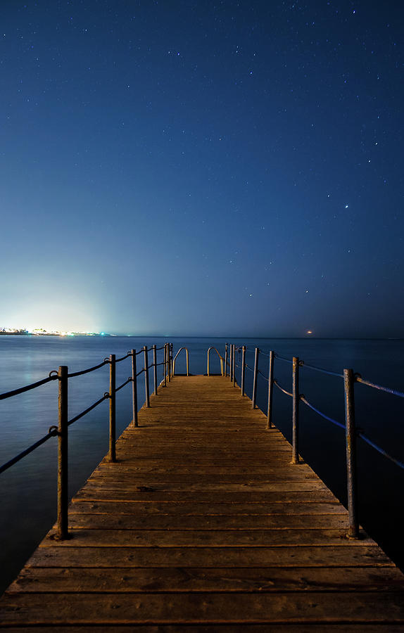 Wooden Dock At Night City Lights, Stars Photograph by Sherif A. Wagih