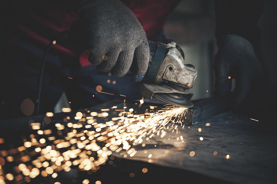 Worker grinding metal close up shot Photograph by Danchooalex