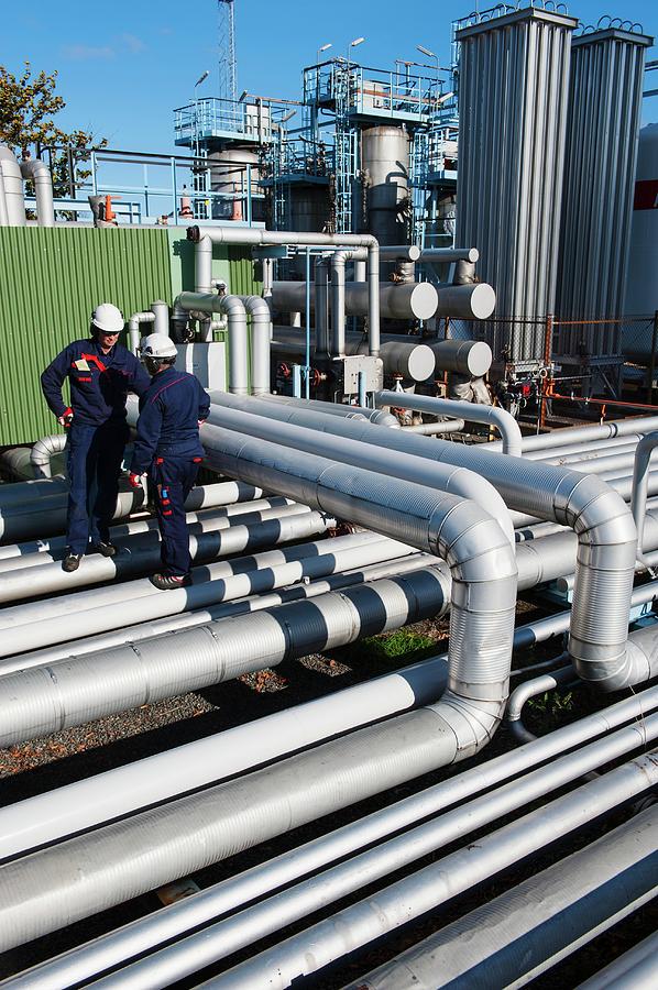 Workers Checking Pipework On An Oil And Gas Refinery Photograph by Christian Lagerek/science Photo Library