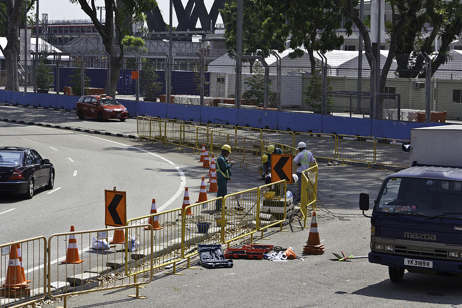 Workers using tools on the road surface and sides in Singapore Photograph by Ashish Agarwal