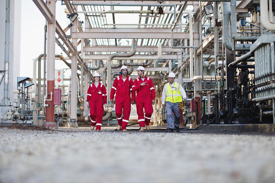 Workers walking at chemical plant Photograph by Hybrid Images