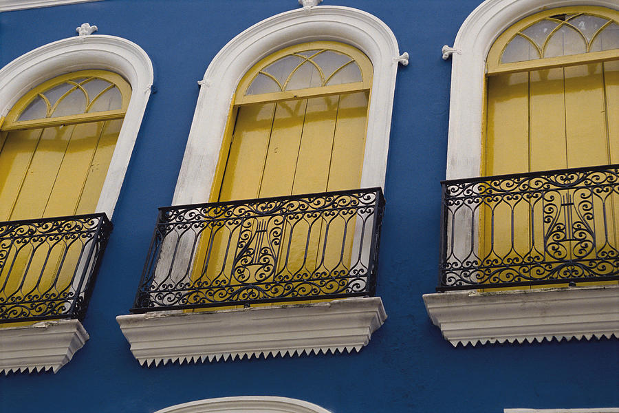 Yellow Curtains Hang From White Framed And Arched Windows On A Blue Home Or Building Photograph by Rubberball/Heinz Hubler