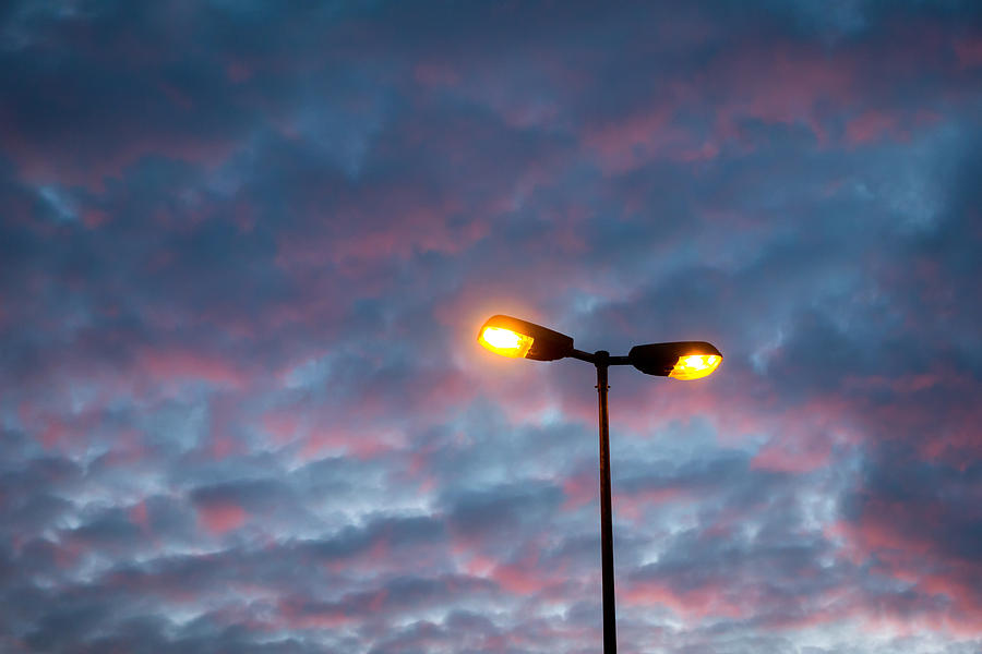 Yellow light post with red and blue sky at sunset Photograph by ...