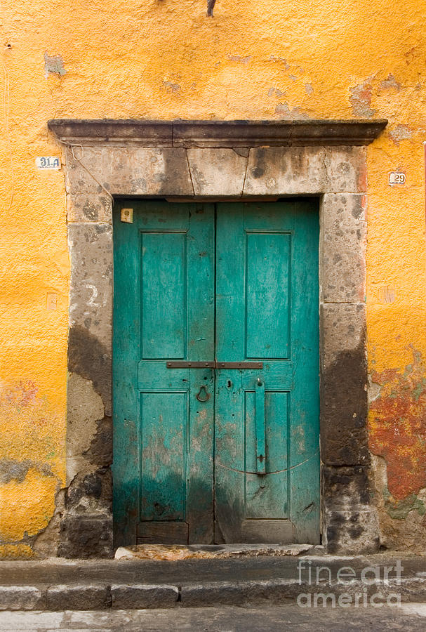 Yellow wall with green door. Photograph by Oscar Gutierrez