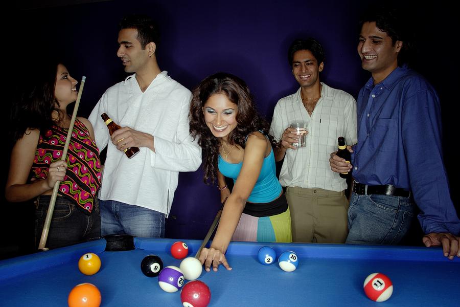 Young adults playing pool and drinking beer Photograph by Asia Images Group