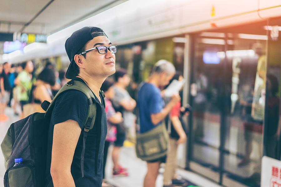 Young asian traveler waiting for transportation underground at Hong Kong MTR Photograph by Mongkol Chuewong