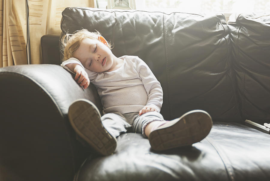 Young baby girl falls asleep on sofa Photograph by Justin Paget