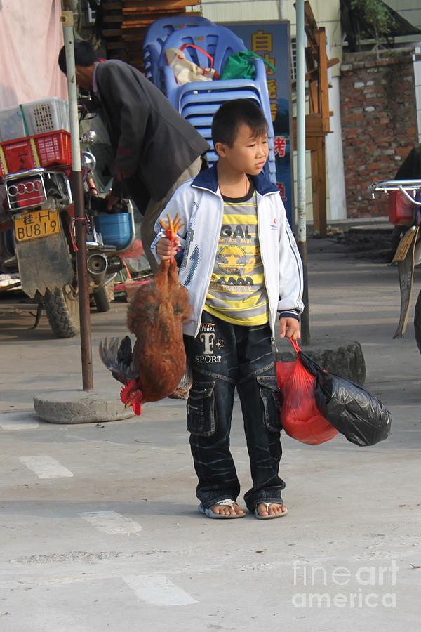 Young boy carrying a dead chicken to school Photograph by Thomas Marchessault