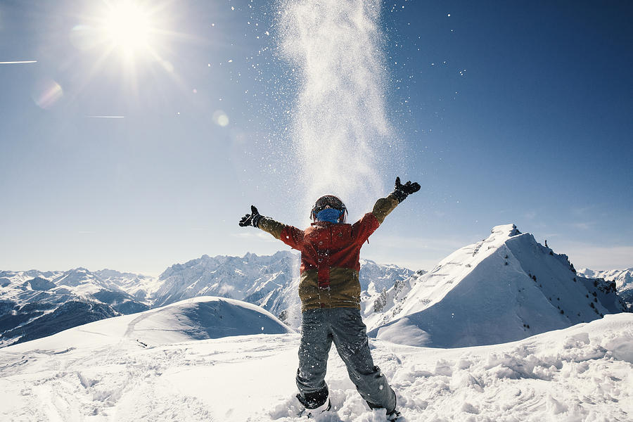 Young boy enjoying sun and snow fun on top of a mountain Photograph by Luca Sage