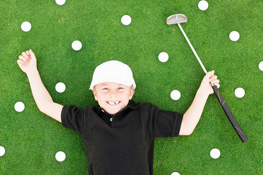Young Boy Having Fun On Golf Course Photograph by MichaelSvoboda