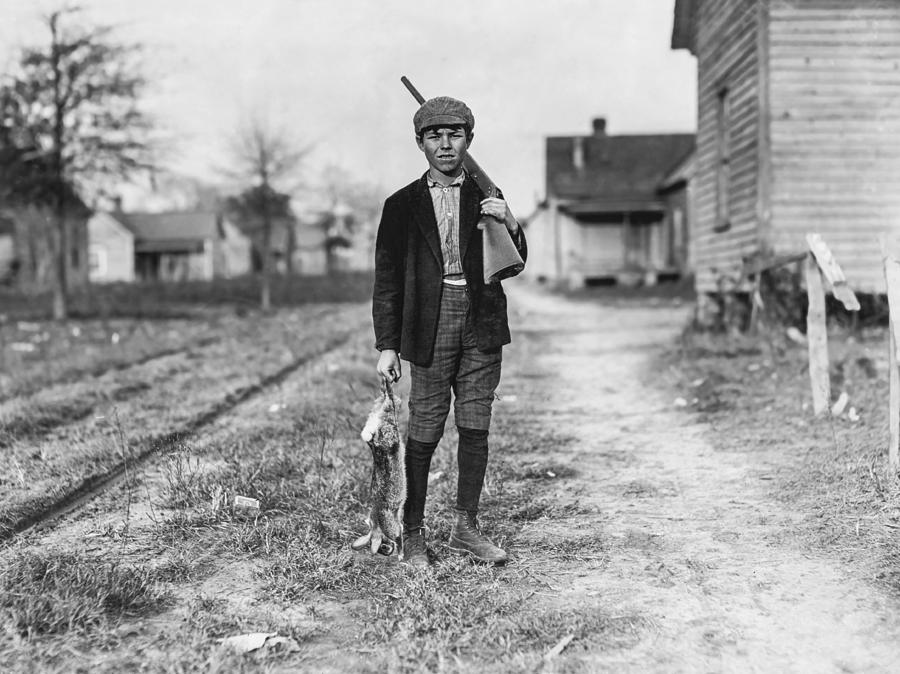 Black And White Photograph - Young boy hunting rabbits by Aged Pixel