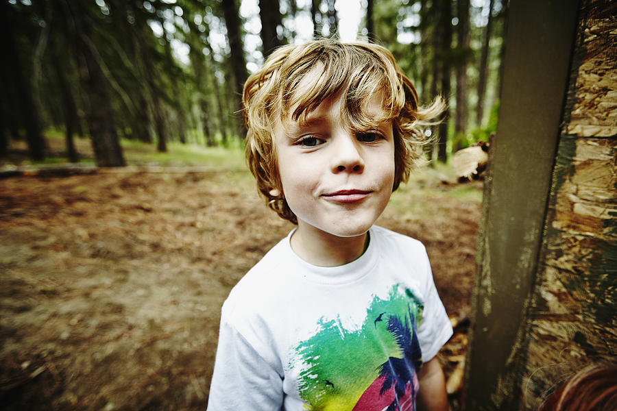 Young boy standing in the woods at camp Photograph by Thomas Barwick
