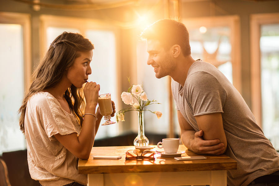Young couple in love spending time together in a cafe. Photograph by Skynesher
