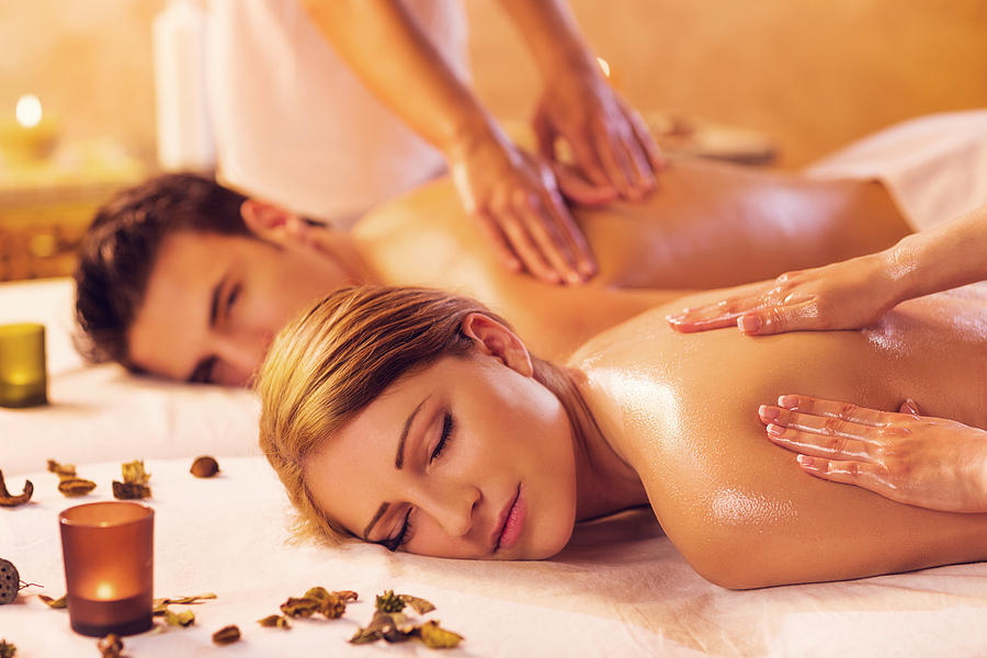Young couple relaxing during a back massage at the spa. Photograph by BraunS