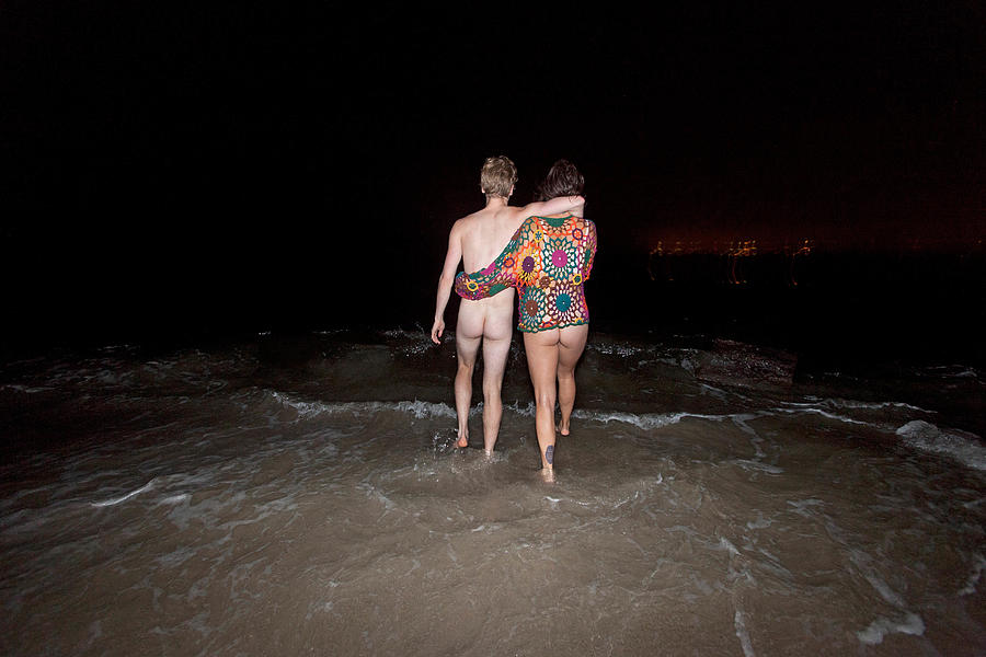 Young couple streaking on a beach at night Photograph by Hex