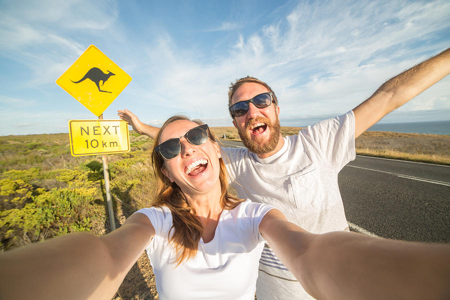 Young couple take selfie portrait near kangaroo warning sign-Australia Photograph by Swissmediavision