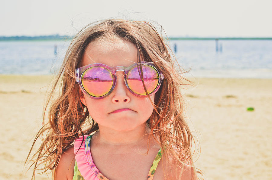 Young girl at the beach wearing sunglasses. Photograph by Fran Polito