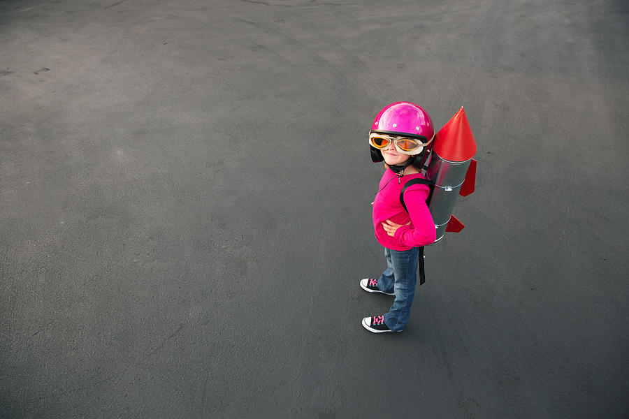 Young girl dressed in a red rocket suit on blacktop Photograph by Andrew Rich