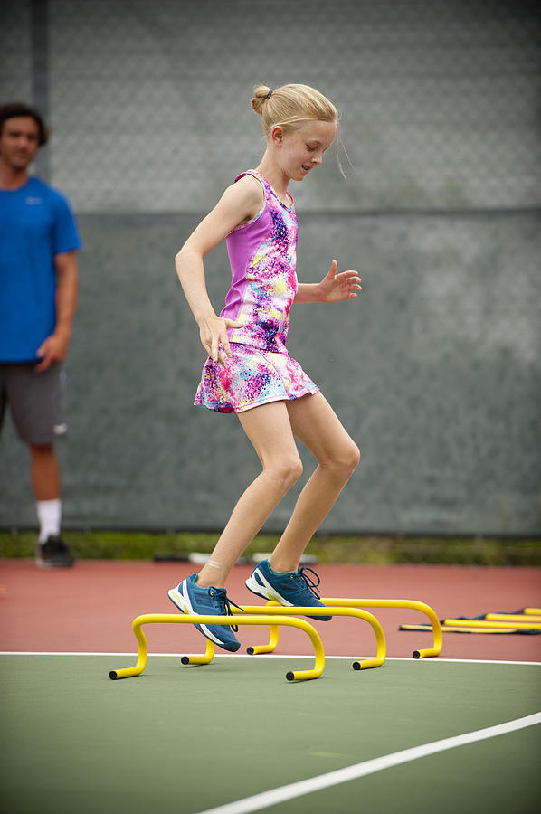 Young Girl In Tennis Camp Drills Photograph by Stephen Simpson