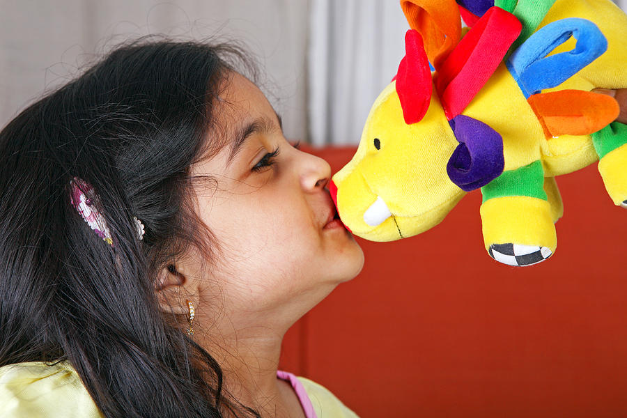 Young girl kissing a soft toy Photograph by Visage
