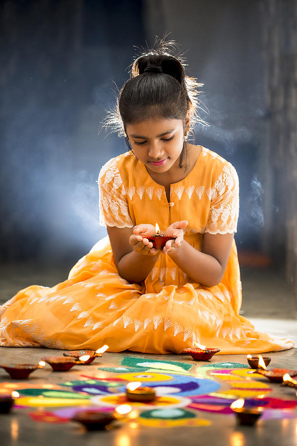 Young Girl making Rangoli, decorating with oil lamps for Diwali Photograph by SoumenNath