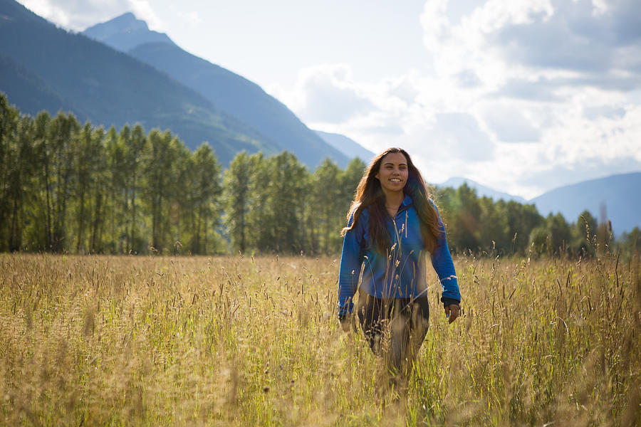 Young indigenous Canadian woman walking in a field Photograph by Nattrass