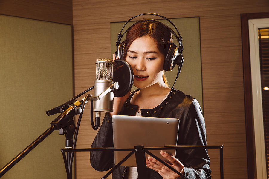 Young lady recording vocals in studio Photograph by Images By Tang Ming Tung