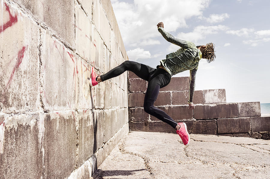 Young man, free running, outdoors, running up side of wall Photograph by Igor Emmerich
