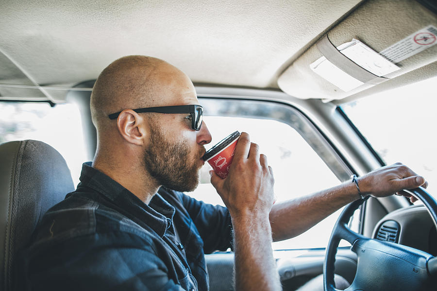 Young man with sunglasses and beard on a road trip with takeaway drink Photograph by Westend61