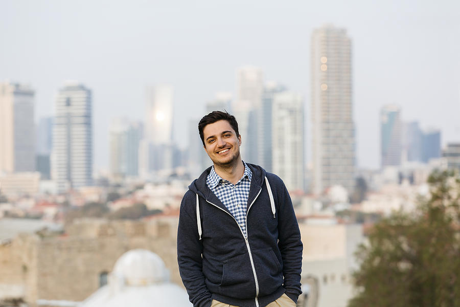 Young man with Tel Aviv skyline background Photograph by Alexander Spatari